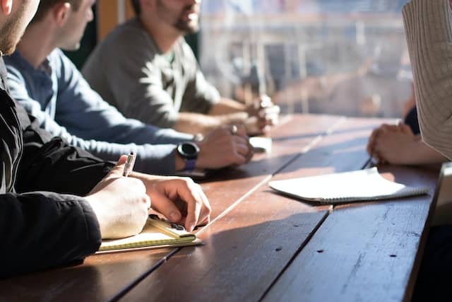 people sitting at a table with sun shining through
